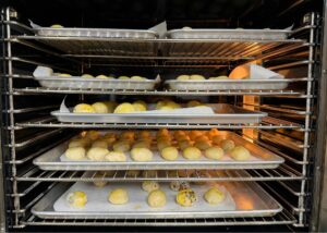 Trays of handmade egg yolk pastries baking in the oven